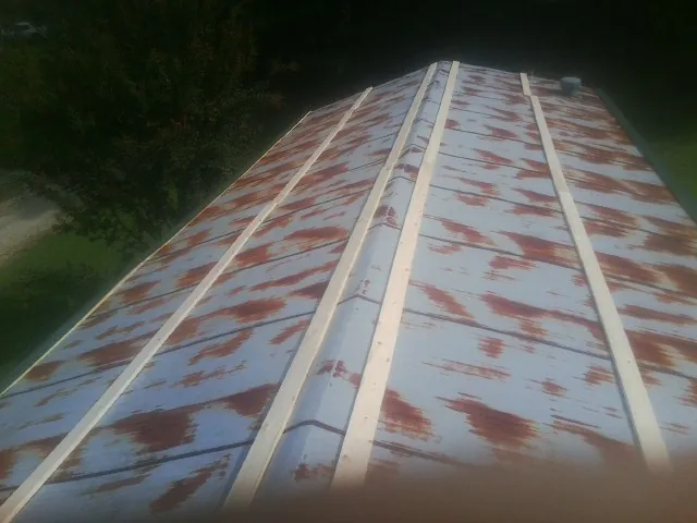 Rusted metal roof panels with new wood purlins before replacement — Storm Damage Roof Repair in Ossipee by Roofing Brothers